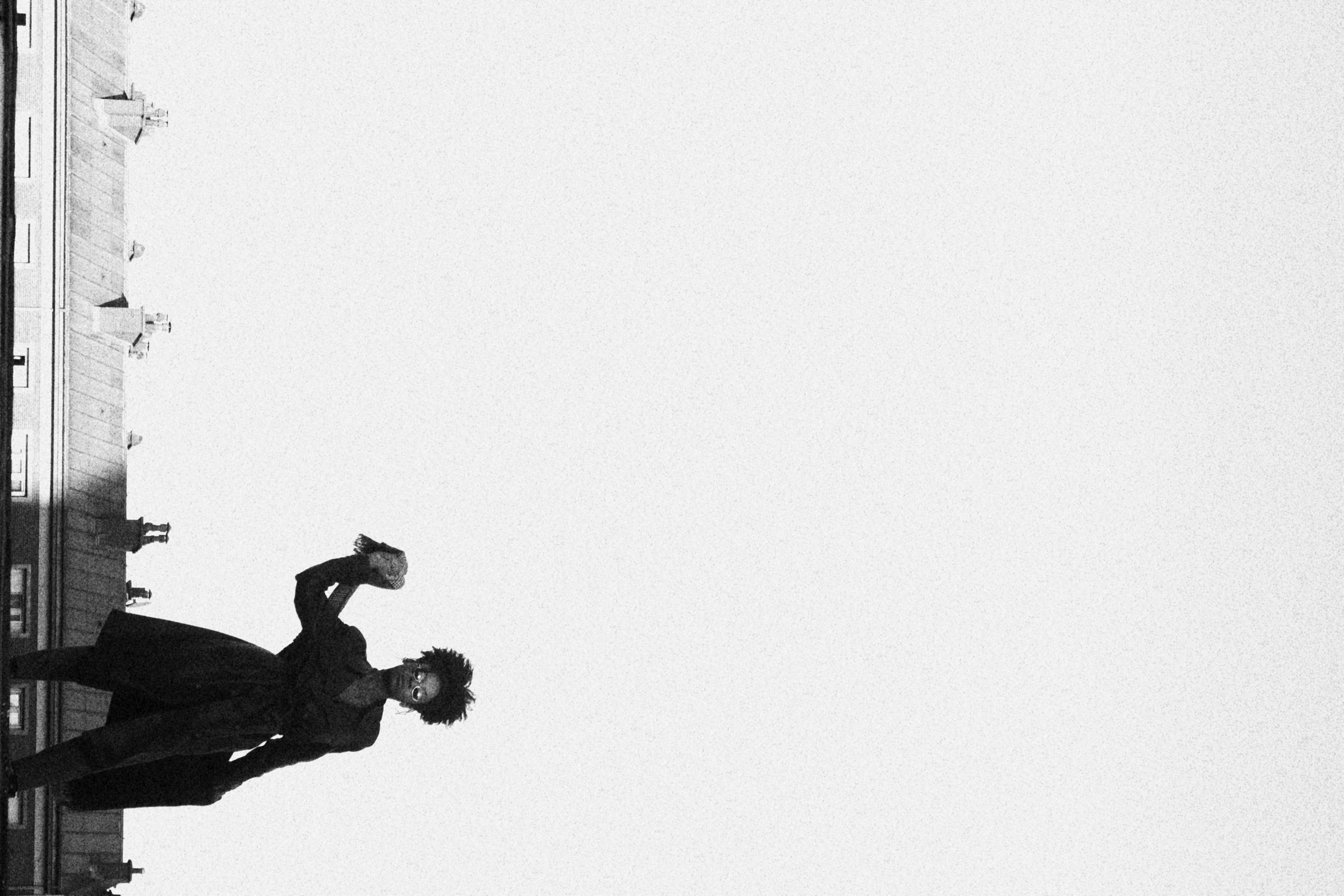  photo en nuance de gris, femme de 3/4 regardant le ciel, vue en contre plongé - made by Kodjo
